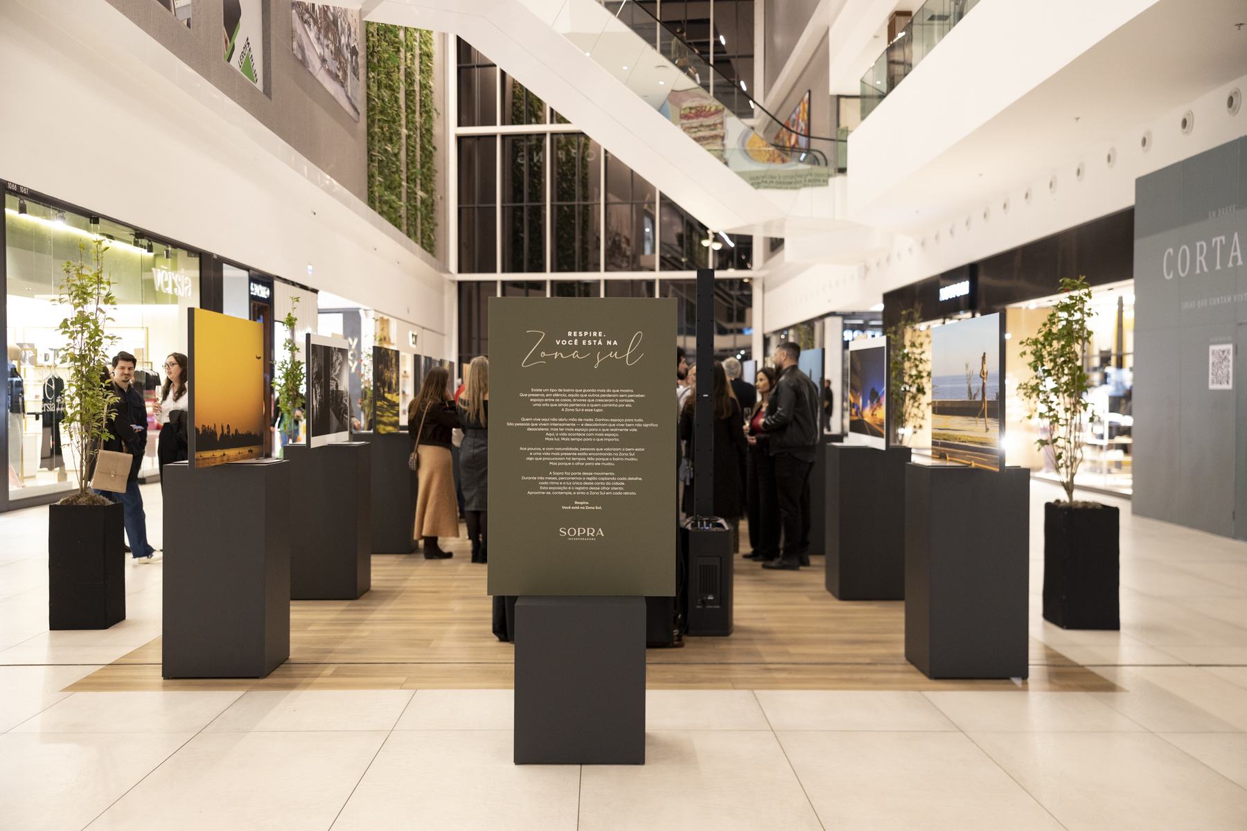 Corredor do Pontal Shopping com os painéis pretos da exposição e o totem do movimento Respire